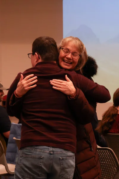 Two people smiling and hugging.