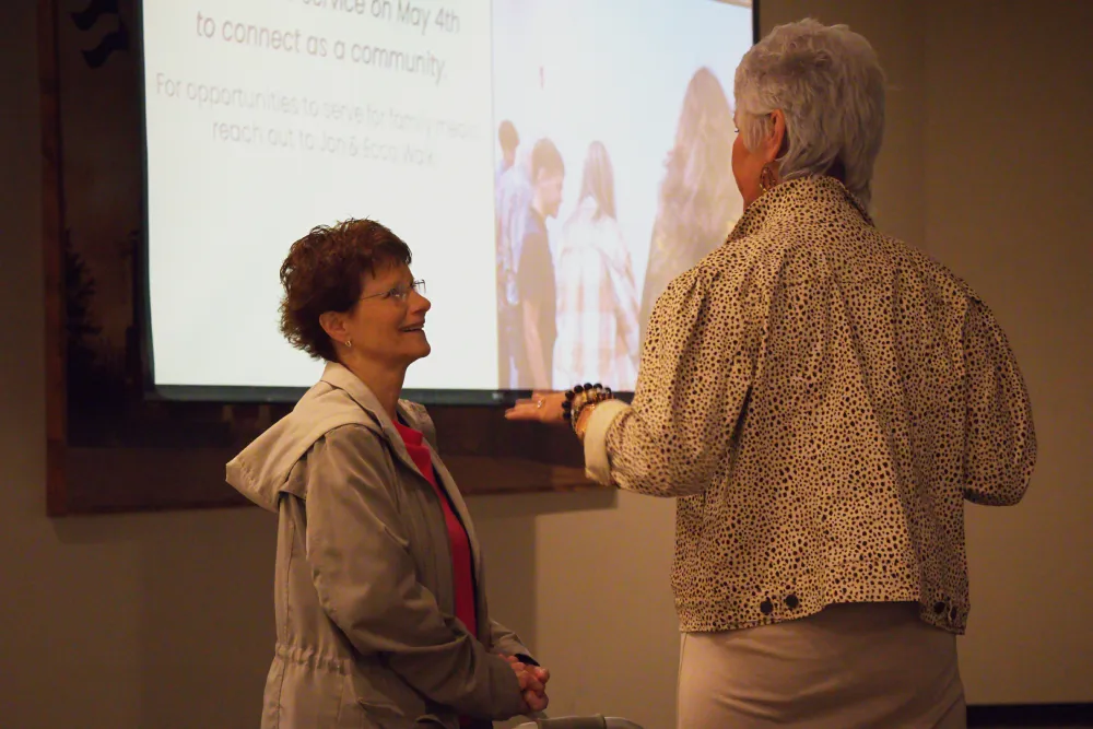 Two women talking and smiling.