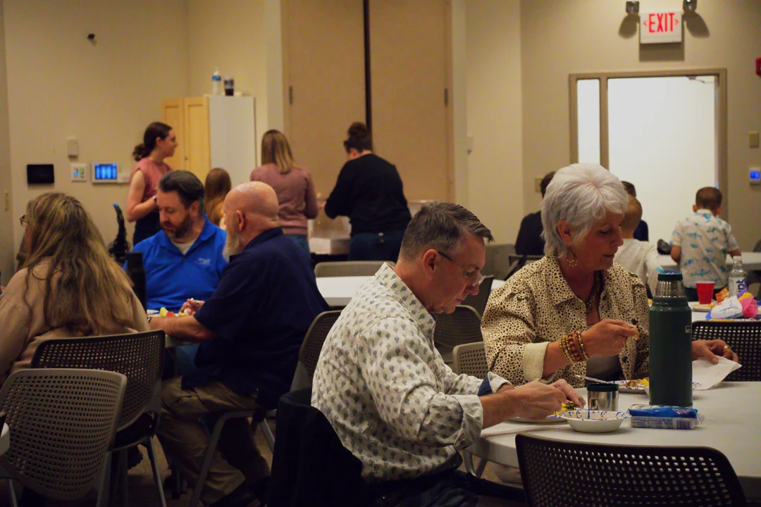 Wide picture of our monthly family meals with people eating and connecting.